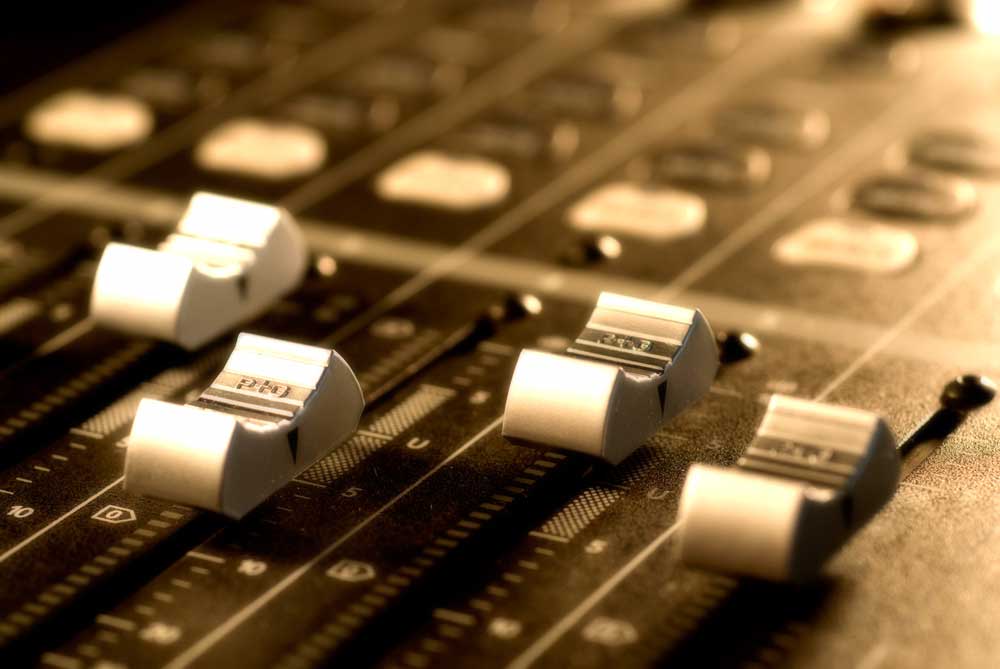 close up of mixing board sliders